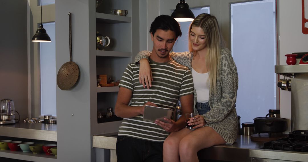 Happy Couple Relaxing in Modern Kitchen Using Digital Tablet
