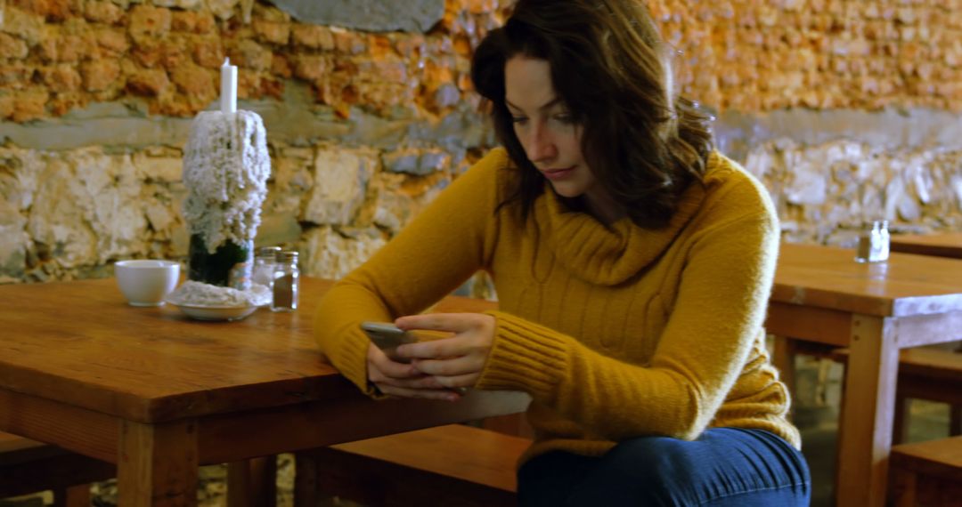 Woman Using Smartphone in Cozy Cafe with Rustic Decor - Free Images, Stock Photos and Pictures on Pikwizard.com