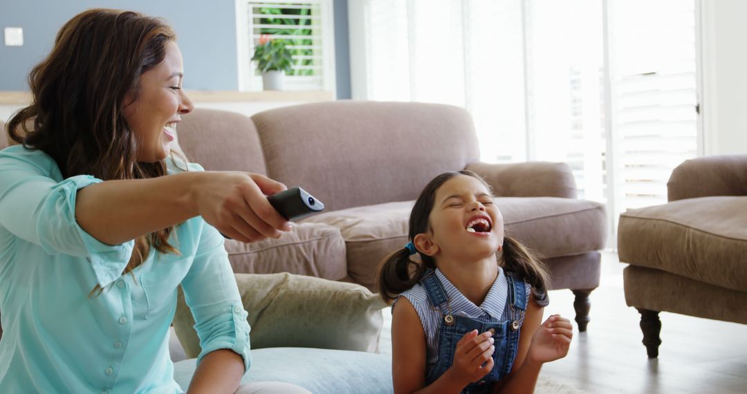 Mother and Daughter Laughing Together Watching TV in Living Room - Free Images, Stock Photos and Pictures on Pikwizard.com