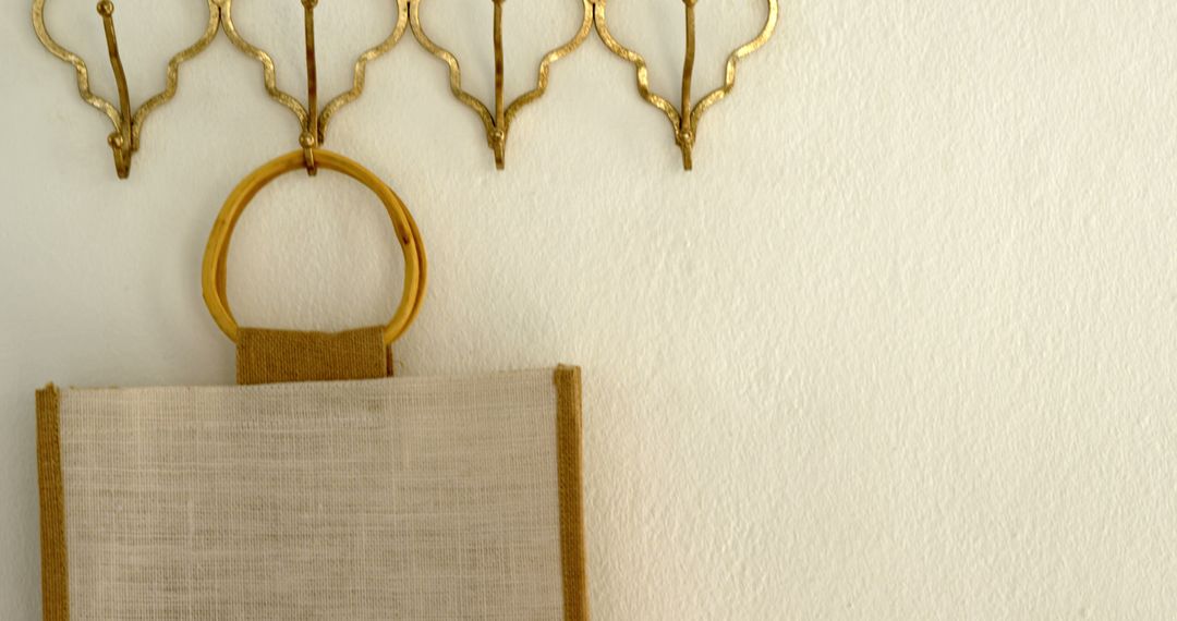 A minimalist wall decor with a canvas bag and golden sconces exudes serene sophistication. - Free Images, Stock Photos and Pictures on Pikwizard.com
