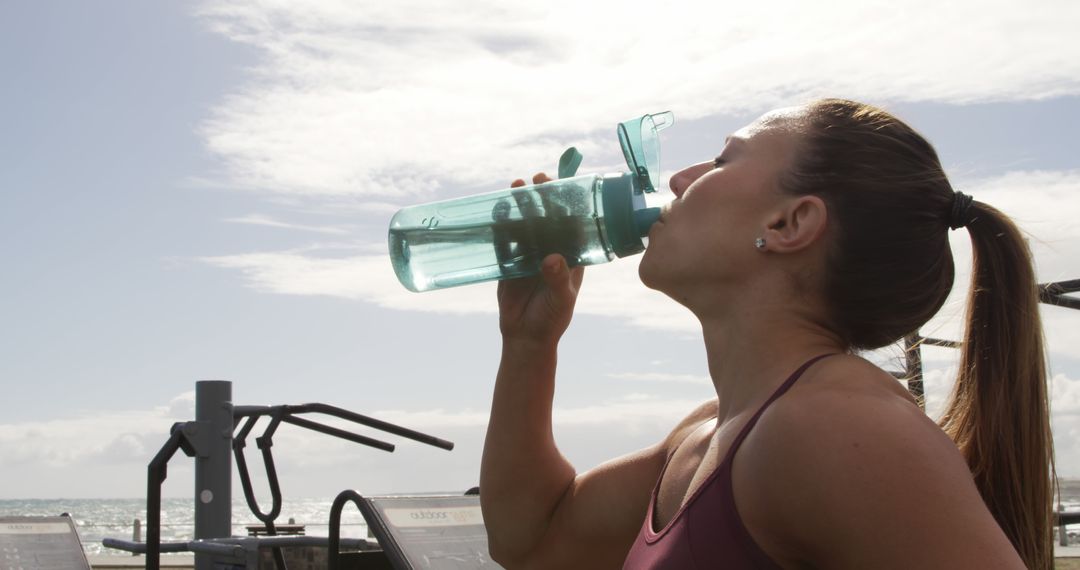 Fit Woman Drinking Water During Outdoor Workout by Seaside - Free Images, Stock Photos and Pictures on Pikwizard.com