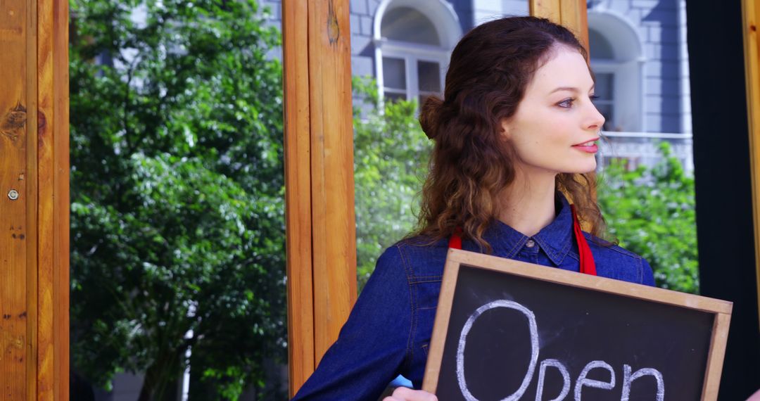 Young Woman Holding Chalkboard Sign Saying Open Outside Shop - Free Images, Stock Photos and Pictures on Pikwizard.com