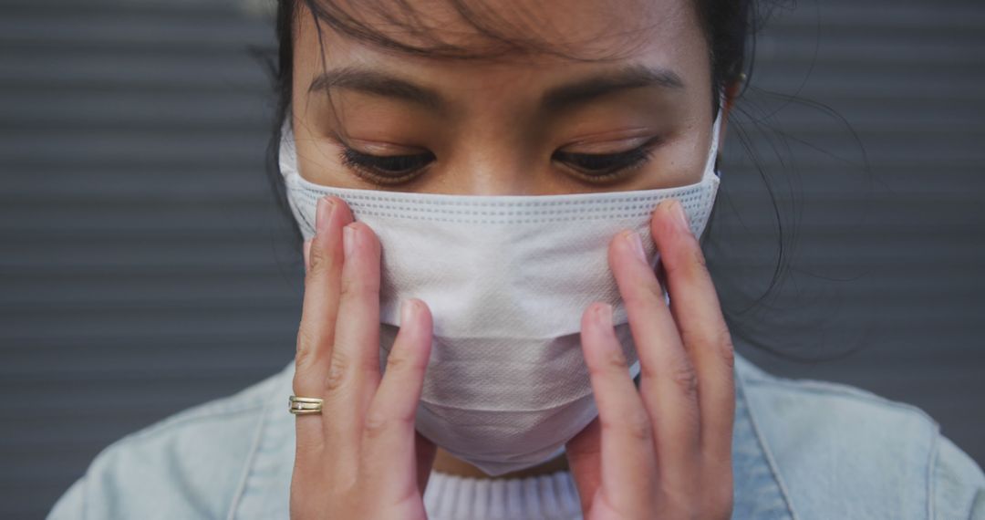 Woman Adjusting Protective Face Mask During Pandemic - Free Images, Stock Photos and Pictures on Pikwizard.com