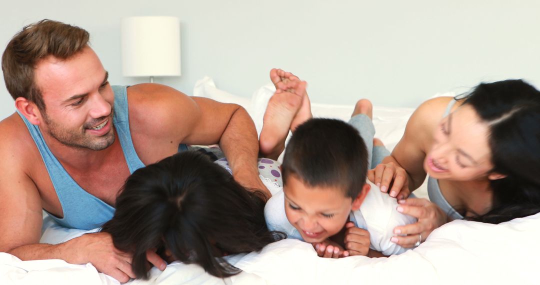 Happy Family Playing and Laughing on Bed - Free Images, Stock Photos and Pictures on Pikwizard.com