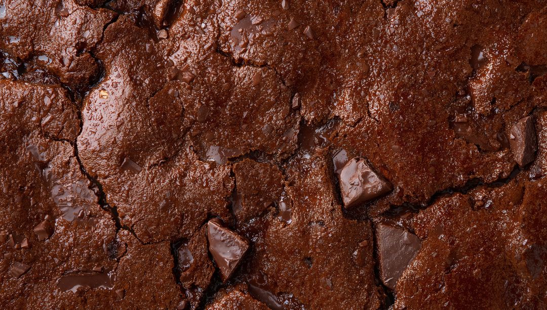 Glistening Fudgy Chocolate Brownie Close-Up with Melted Chunks and Cracked Surface