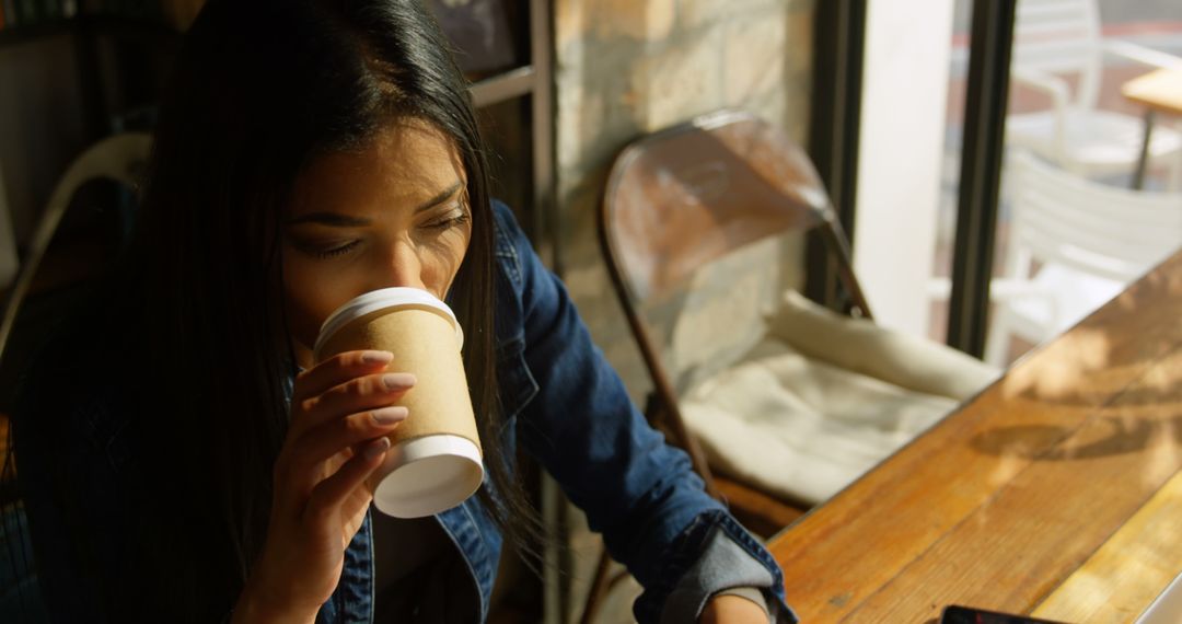 Young Woman Drinking Coffee at Cozy Cafe - Free Images, Stock Photos and Pictures on Pikwizard.com