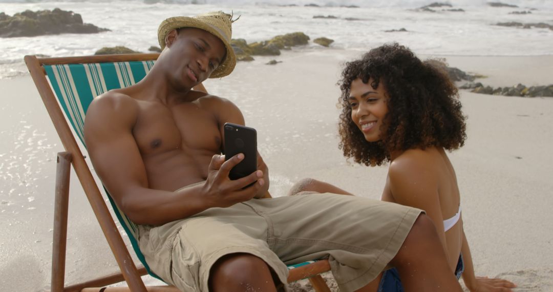 Couple Relaxing on Beach with Mobile Phone