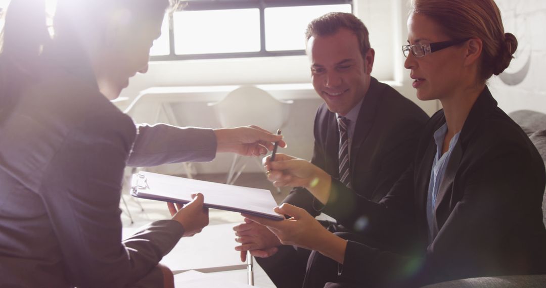 Business Professionals Signing Important Documents in Meeting