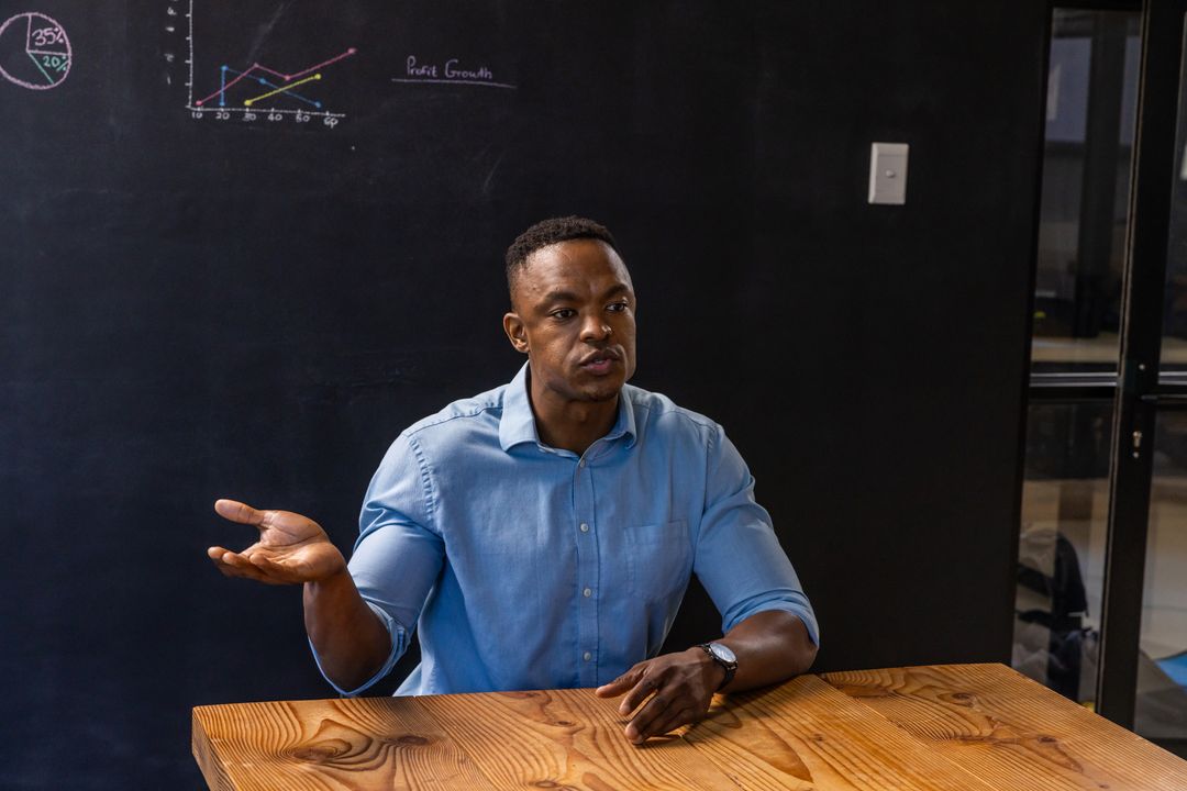 Business Professional Analyzing Chalkboard Data in Modern Meeting Room