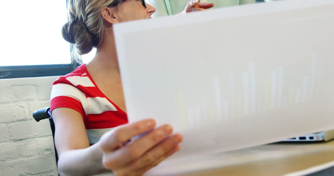 Businesswoman Analyzing Financial Graph at Office Desk - Free Images, Stock Photos and Pictures on Pikwizard.com