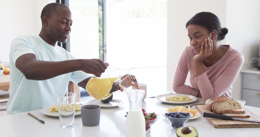 Happy Couple Enjoying Breakfast Together at Kitchen Table
