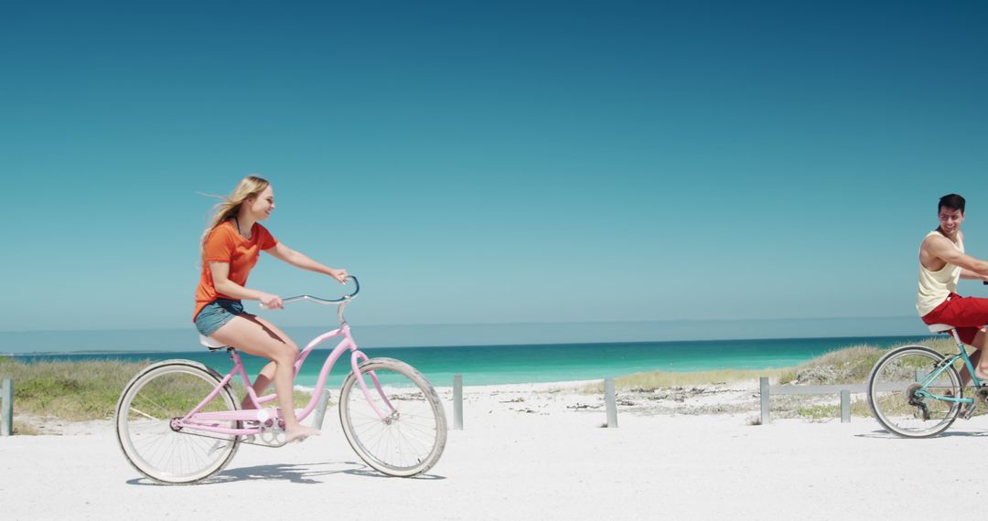 Joyful Couple Cycling on Seaside Path in Summer