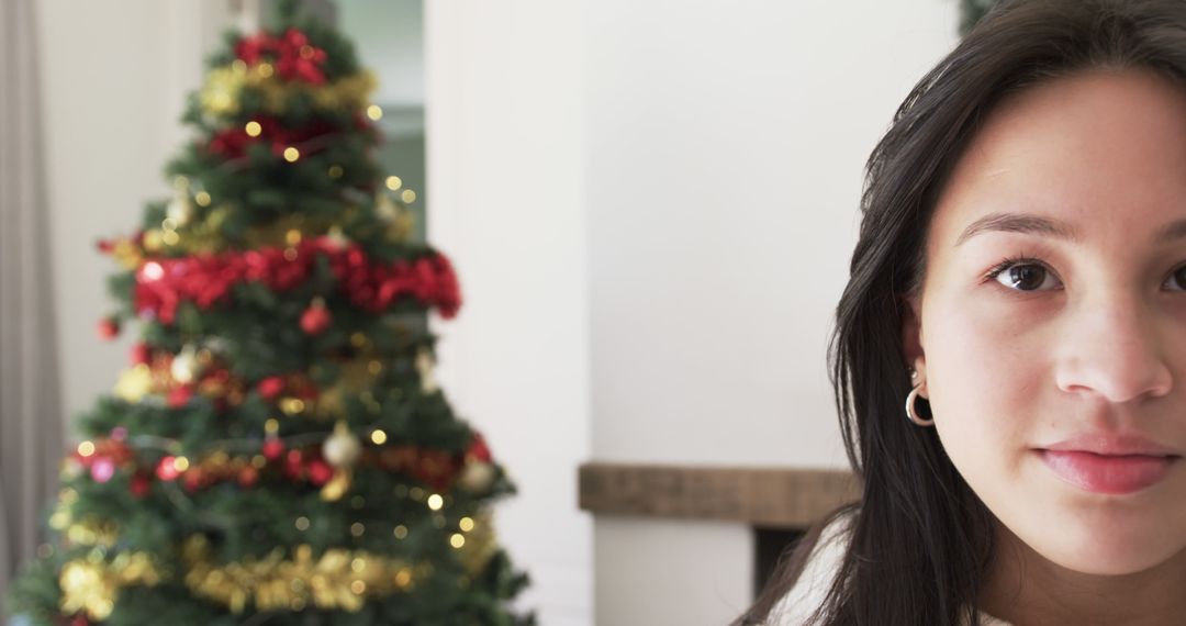 Festive Biracial Woman Smiling by Decorated Christmas Tree - Free Images, Stock Photos and Pictures on Pikwizard.com