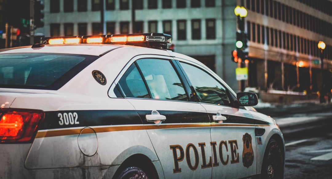 Urban Police Patrol Car on City Street at Dusk