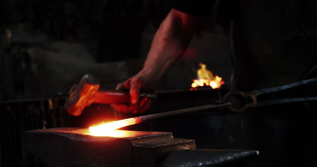 Blacksmith Forging Hot Metal Workpiece in Dimly Lit Workshop - Free Images, Stock Photos and Pictures on Pikwizard.com