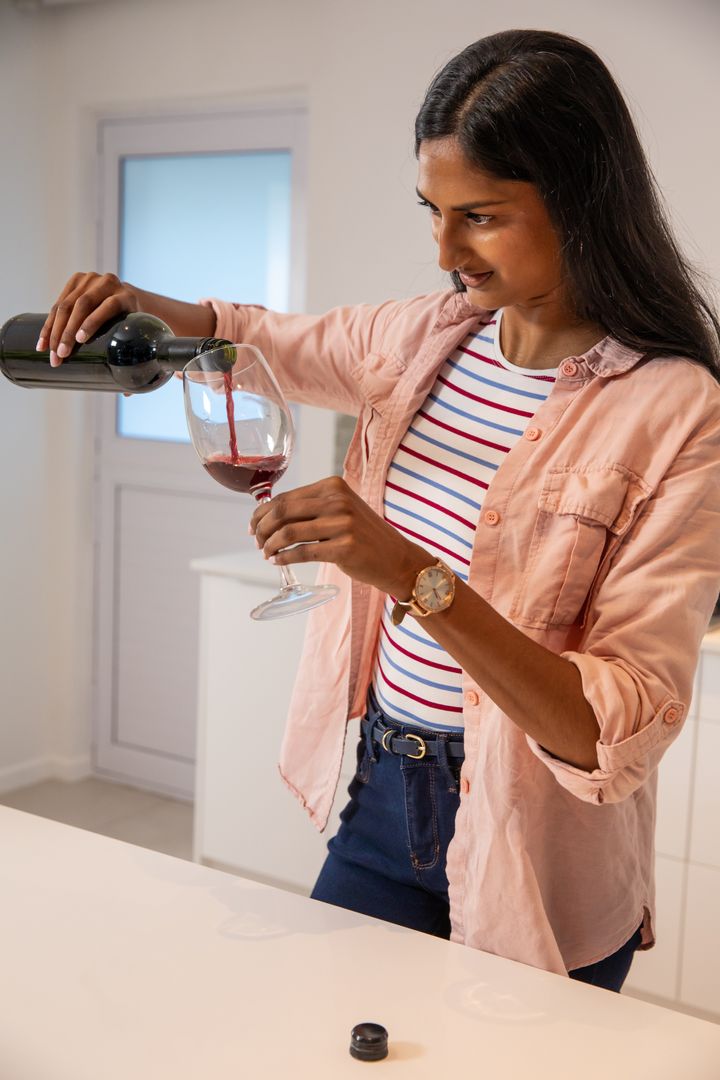 Woman Pouring Wine in Modern Home Kitchen