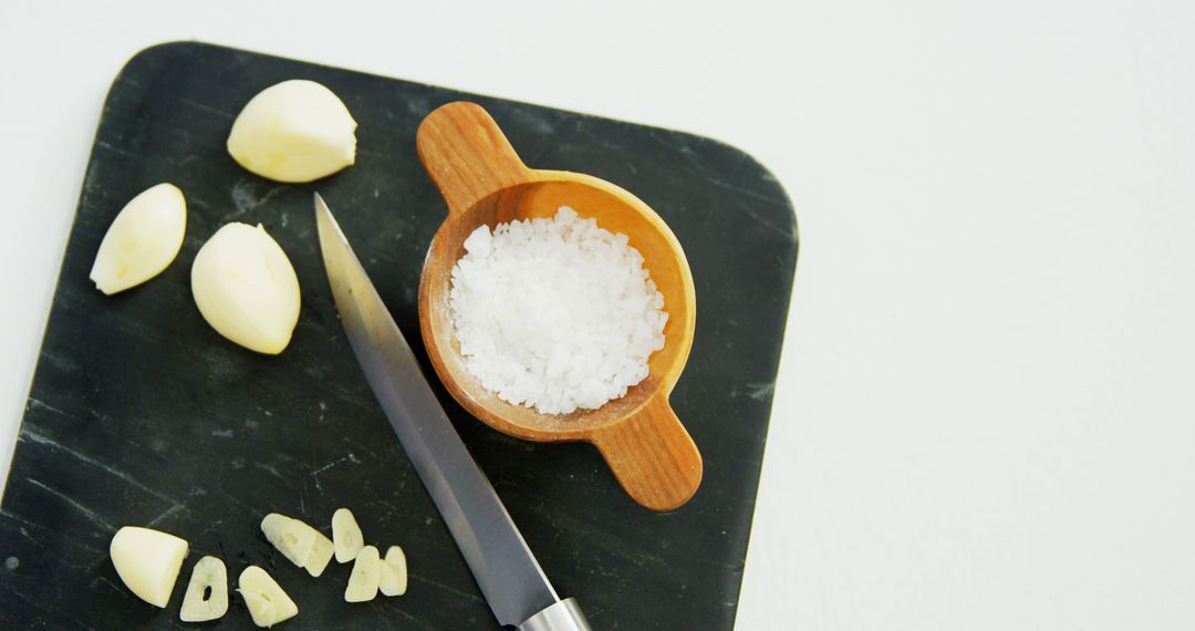 Garlic Cloves and Sea Salt on Cutting Board with Knife - Free Images, Stock Photos and Pictures on Pikwizard.com