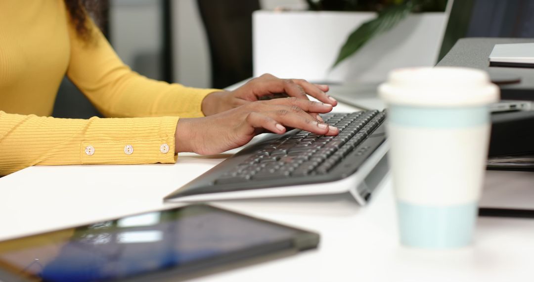 Professional Workspace with Hands Typing on Keyboard