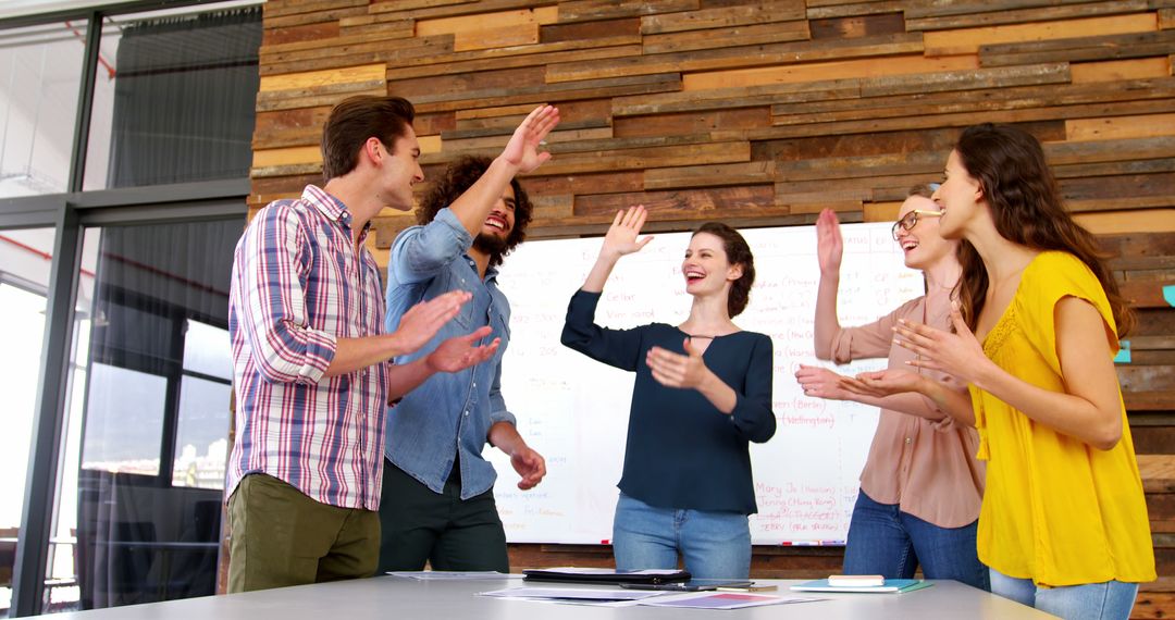 Team celebrating a successful project with high-fives in modern office - Free Images, Stock Photos and Pictures on Pikwizard.com