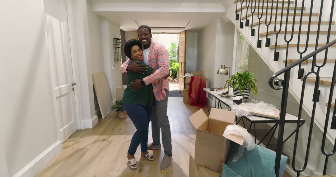 Couple Smiling While Unpacking in New Home