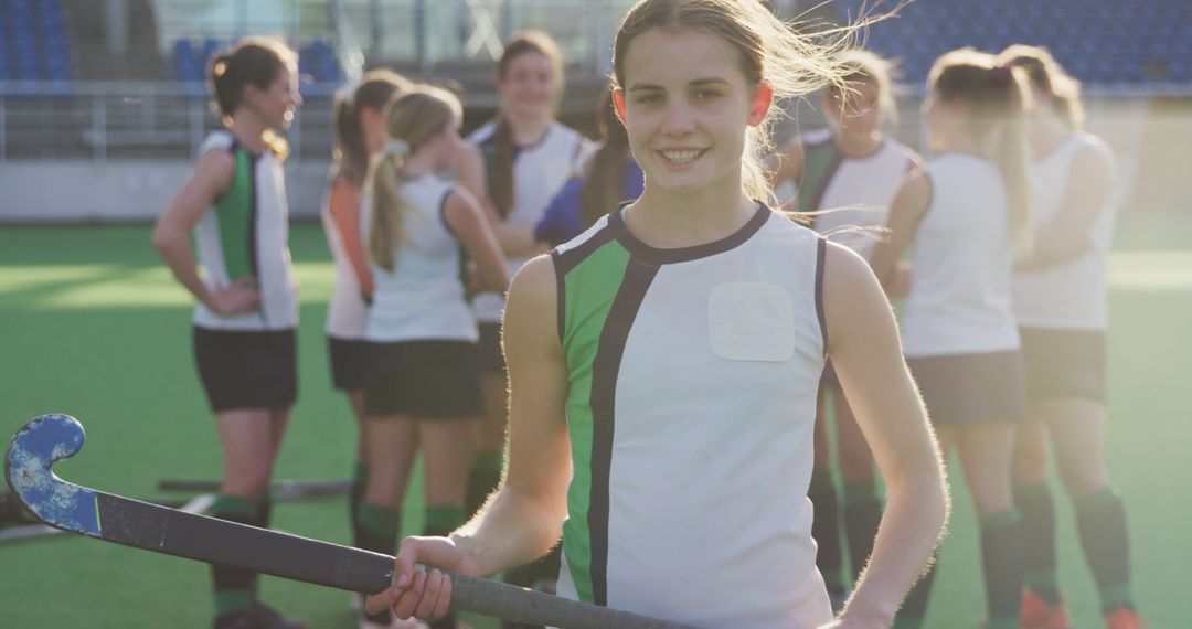 Smiling Field Hockey Player with Team in Background - Free Images, Stock Photos and Pictures on Pikwizard.com