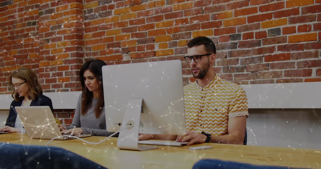 Team Collaborating Using Computers in Modern Office