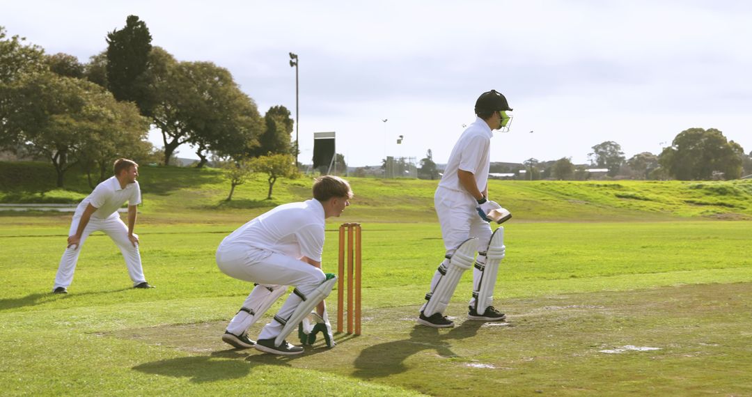 Male Cricketer Batting with Wicketkeeper on Field in Daylight
