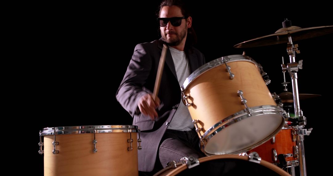 Drummer playing his drum kit on black background - Free Images, Stock Photos and Pictures on Pikwizard.com