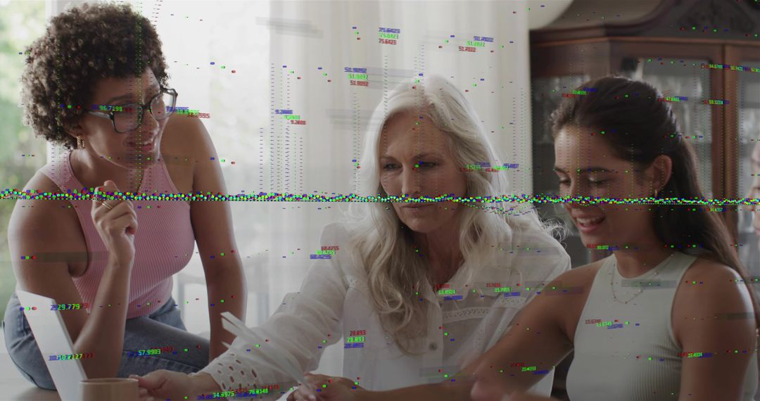 Multigenerational women collaborating over documents at dining table with laptop, daylight