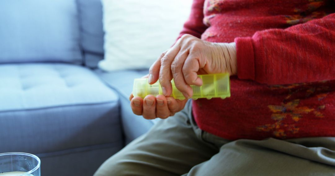 Elderly Person Taking Daily Medication from Pill Organizer at Home - Free Images, Stock Photos and Pictures on Pikwizard.com