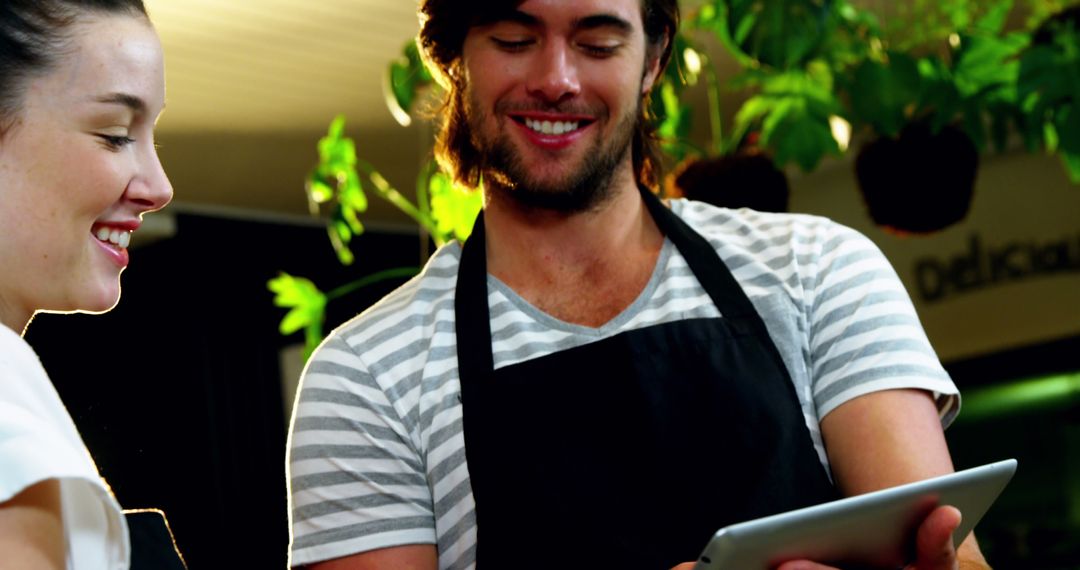 Young Cafe Workers Using Digital Tablet Smiling Together - Free Images, Stock Photos and Pictures on Pikwizard.com