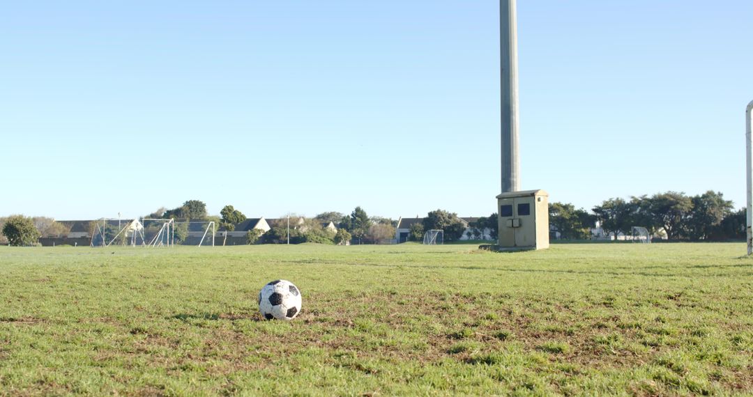 Soccer Ball on Suburban Field Near Goalpost and Light Pole