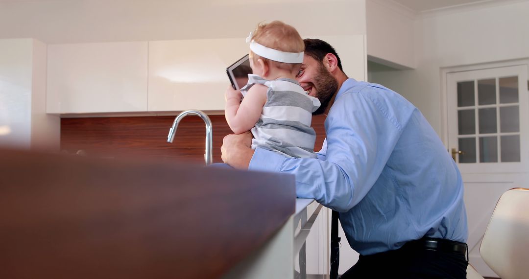 Father Playing with Baby in Modern Kitchen - Free Images, Stock Photos and Pictures on Pikwizard.com