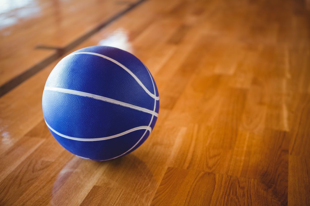 Close up of blue basketball on hardwood floor  - Free Images, Stock Photos and Pictures on Pikwizard.com