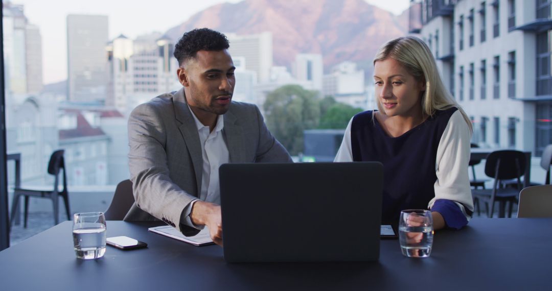 Colleagues Discussing Project on Laptop in Modern Office
