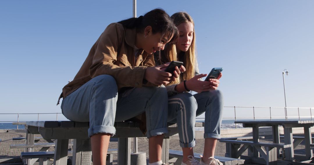 Teen Friends Sitting Outdoors Using Smartphones - Free Images, Stock Photos and Pictures on Pikwizard.com