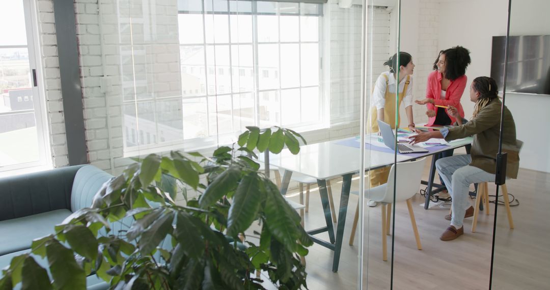 Diverse Colleagues Engaged in Office Meeting by Large Windows