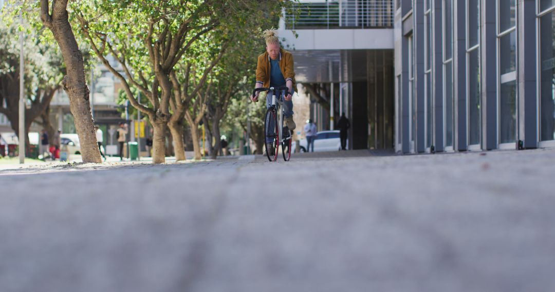 Urban Cyclist Commuting on Sunny Day by Modern Buildings - Free Images, Stock Photos and Pictures on Pikwizard.com