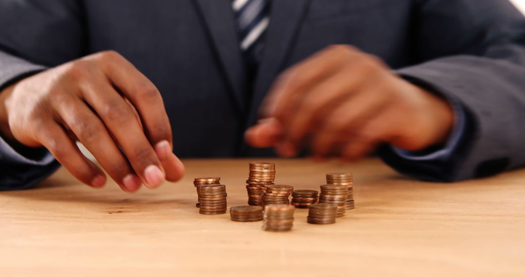 Businessman Counting Coins at Desk for Financial Planning - Free Images, Stock Photos and Pictures on Pikwizard.com