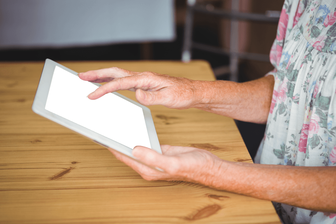 Senior Woman Using Transparent Screen Tablet at Home