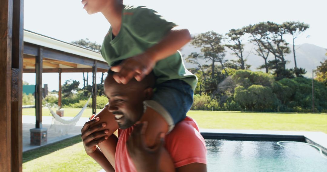 Father Carrying Excited Son on Shoulders in Backyard near Swimming Pool - Free Images, Stock Photos and Pictures on Pikwizard.com