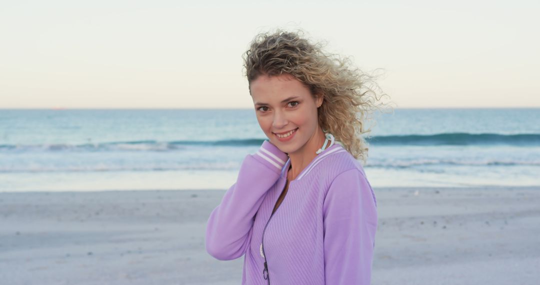 Smiling Woman with Curly Hair Enjoying Beach at Sunset - Free Images, Stock Photos and Pictures on Pikwizard.com