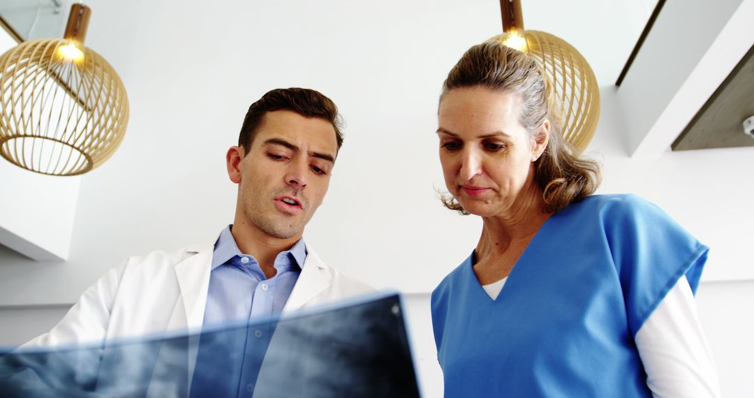 Two Medical Professionals Reviewing Patient X-Ray - Free Images, Stock Photos and Pictures on Pikwizard.com