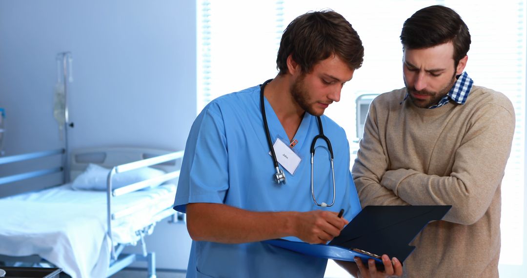 Doctor Discusses Patient File with Attentive Male Relative in Hospital Room - Free Images, Stock Photos and Pictures on Pikwizard.com