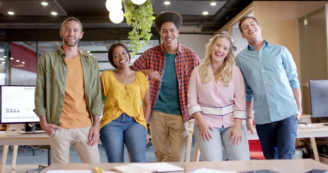 Diverse Team of Young Professionals Celebrating in Modern Office
