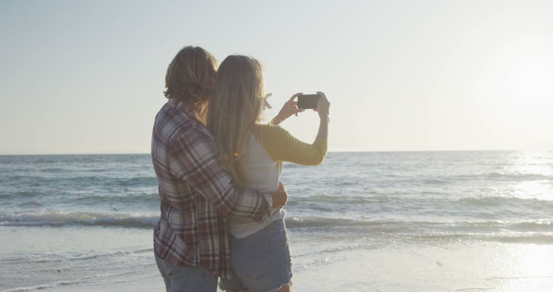 Couple Taking Selfie on Beach during Sunset - Free Images, Stock Photos and Pictures on Pikwizard.com