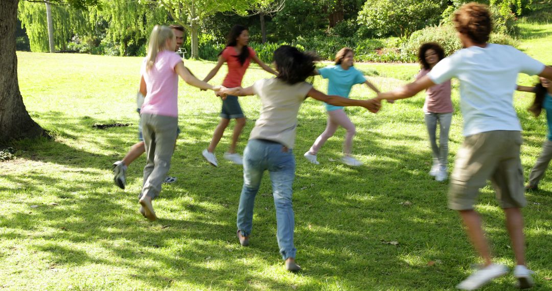 Group of Friends Holding Hands and Playing Outdoors in Sunny Park - Free Images, Stock Photos and Pictures on Pikwizard.com