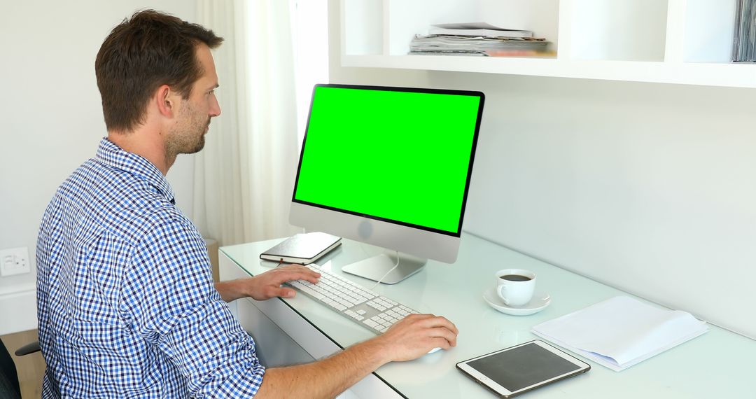Man Working on Computer in Bright Modern Office with Green Screen Display - Free Images, Stock Photos and Pictures on Pikwizard.com