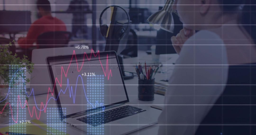 Professional Woman Analyzing Financial Data on Laptop in Open Workspace