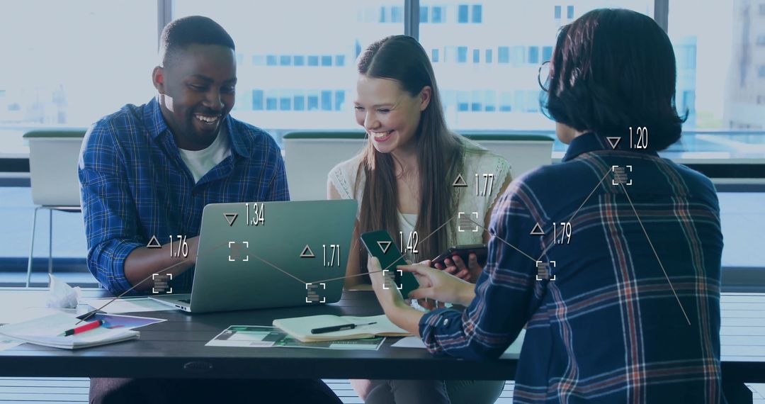 Diverse Team Analyzing Data on Laptop and Smartphone in Modern Office